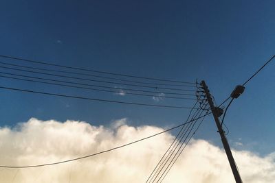 Low angle view of electricity pylon against sky