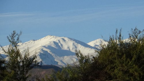 Low angle view of snowcapped mountains against sky