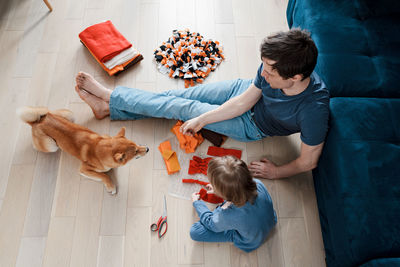 High angle view of friends sitting on wooden floor