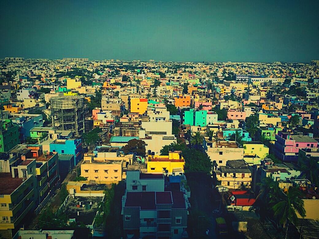 architecture, cityscape, building exterior, built structure, city, crowded, high angle view, skyscraper, day, residential building, outdoors, travel destinations, sky, roof, community, nature, people