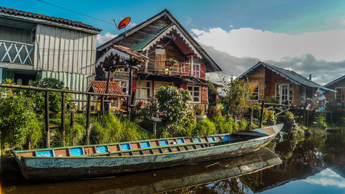 Boats in canal amidst buildings against sky