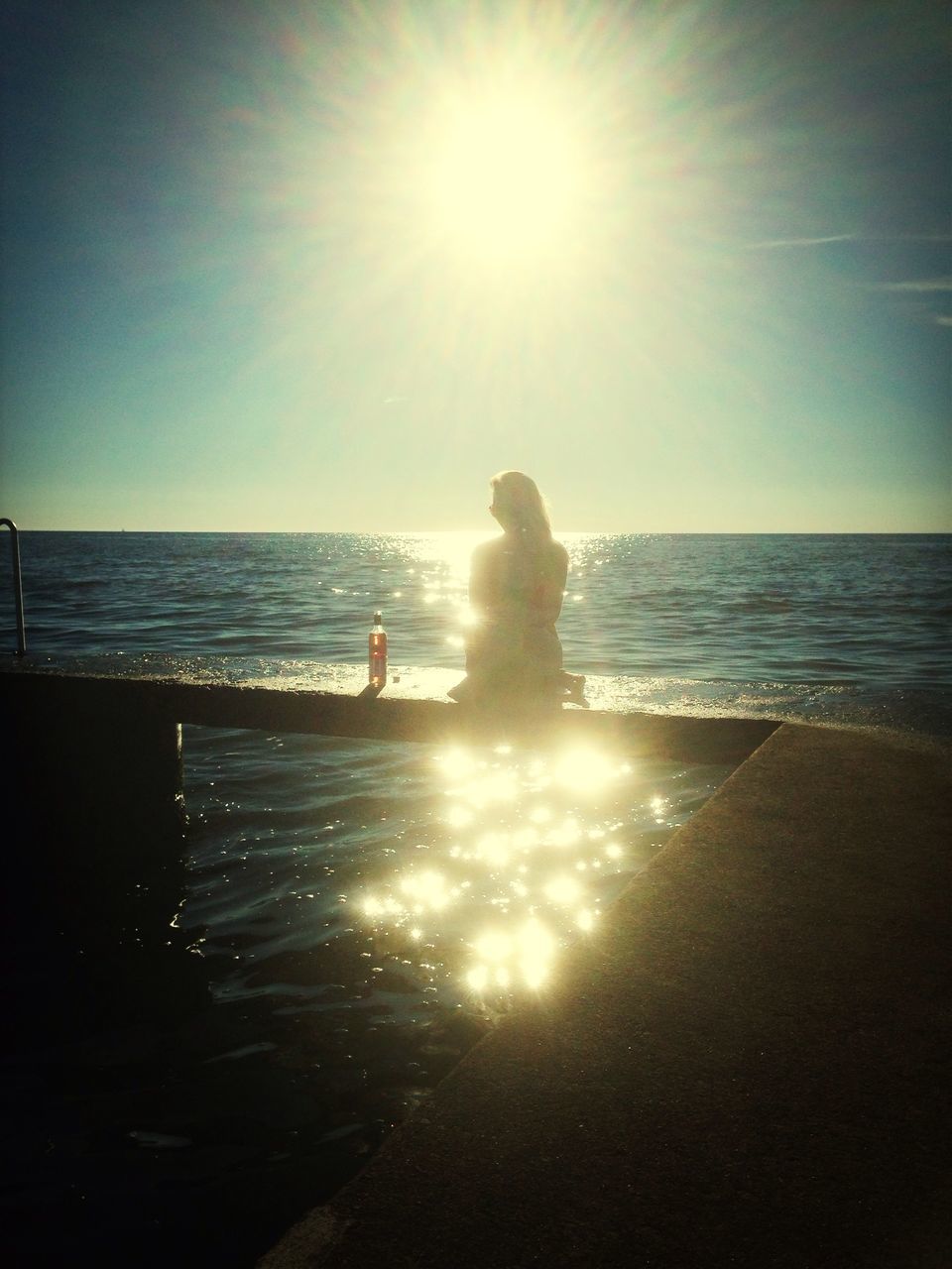 sea, horizon over water, sun, water, beach, sunlight, sunbeam, leisure activity, lifestyles, lens flare, shore, silhouette, sunny, clear sky, vacations, scenics, beauty in nature, full length, sky