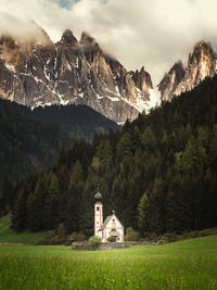 Scenic view of building by mountains against sky