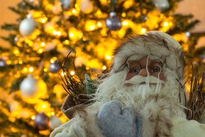 Close-up of santa claus figurine against christmas tree