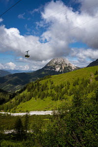 Cable car in the mountains above green meadow