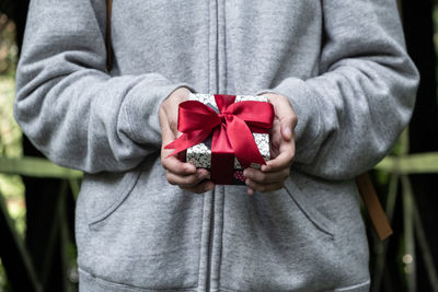 Midsection of man holding red flowers