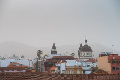 Buildings in city against clear sky