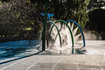 Silhouette of child running through water at park