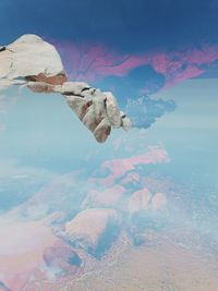 Double exposure of rock formations against sky