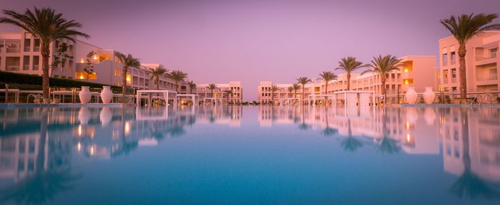 Reflection of palm trees in swimming pool at night