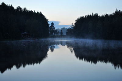Reflection of trees in lake against sky