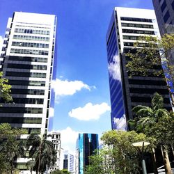 Low angle view of skyscrapers against blue sky