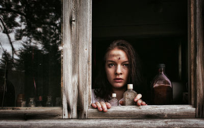 Portrait of worried woman seen through window