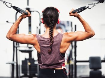 Rear view of woman with arms raised