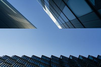 Low angle view of modern buildings against clear blue sky