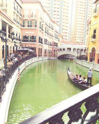 People in boat on canal in city