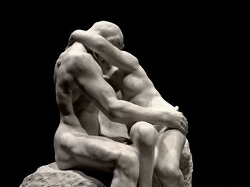 Close-up of hand statue against black background