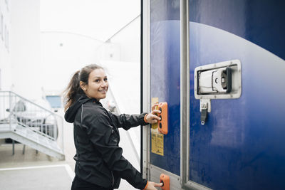 Smiling woman pushing buttons on delivery van