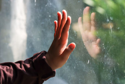 Midsection of man hand on wet glass