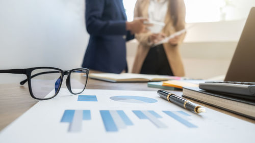 Midsection of businessman working on table