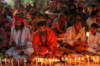 Saint praying at rakher upobash infront of burning candle and incense