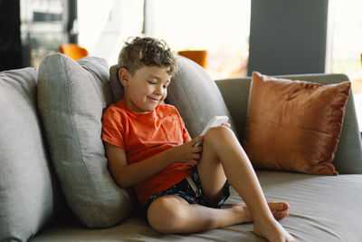 Young woman sitting on sofa at home