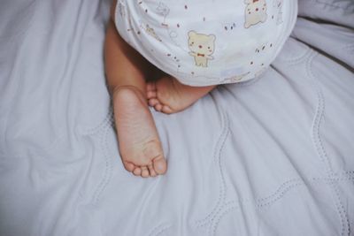 Midsection of baby on bed at home