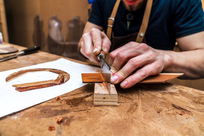 Midsection of man working on table