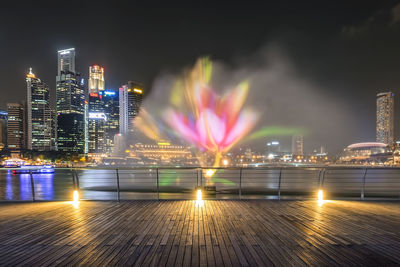 Illuminated city against sky at night