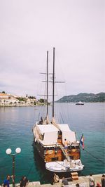 Sailboats moored on sea against sky