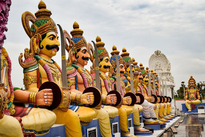 Panoramic view of statues outside building against sky