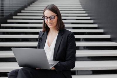 Portrait of young businesswoman using laptop at office