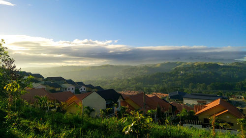 Houses by buildings against sky