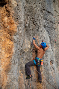 Full length of man climbing on rock