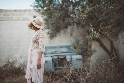 Girl standing by plants on field