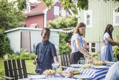 People having food in yard against building