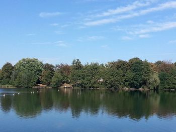 Scenic view of lake by trees against sky