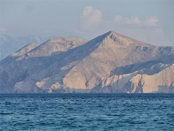 Scenic view of sea and mountains against sky