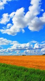 View of field against cloudy sky