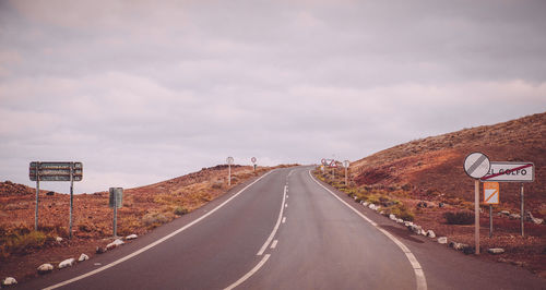 Empty road on mountain against cloudy sky at charco verde