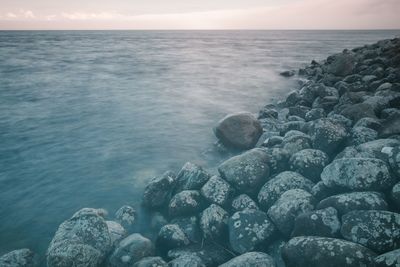 Rocks in sea against sky