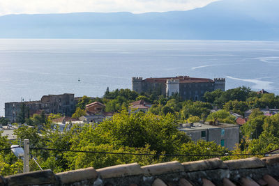 High angle view of townscape by sea against sky