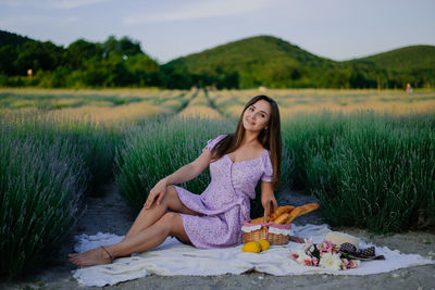 Portrait of young woman sitting on field