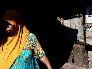 Midsection of woman standing against wall