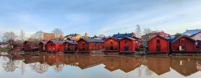 Reflection of buildings on lake against sky