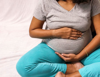 Midsection of woman touching legs