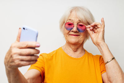 Young woman using mobile phone against white background