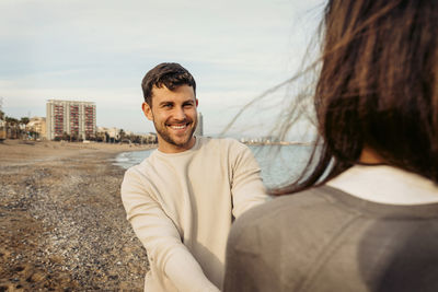 Portrait of smiling young man standing against sky