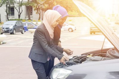 Businessewomen in hijab repairing car engine