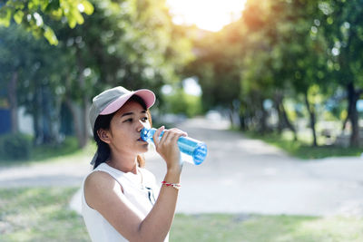 Asian young woman drinking water after jogging,healty and sport concept.